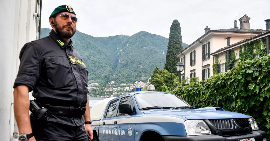 Ein Polizist steht neben einem Polizeiwagen für eine Sicherheitskontrolle vor der Villa Oleandra von Hollywoodstar George Clooney am Comer See.