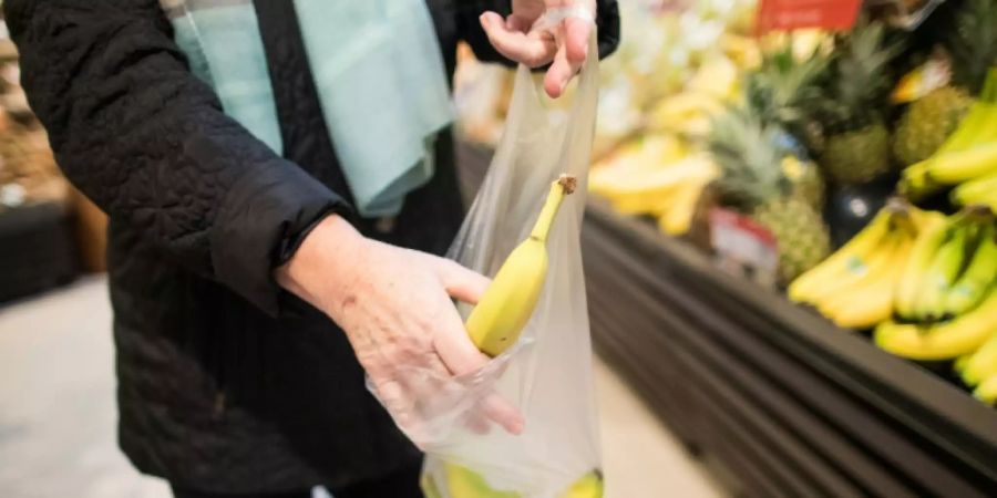 Supermarktkunde packt Bananen in Tüte