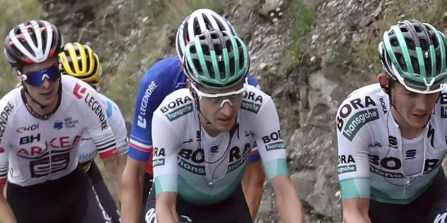 Hat seine Teamkameraden mit einer fehlerlosen Tour-Leistung beeindruckt: Emanuel Buchmann (M) vom Team Bora-hansgrohe. Foto: Thibault Camus/AP
