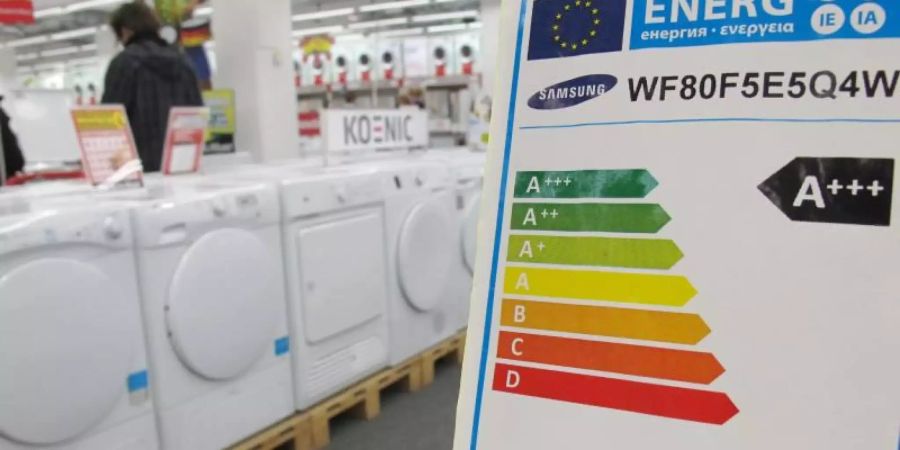 Ein Hinweisschild weist die Energieeffizienzklasse von Waschmaschinen aus. Foto: Peter Kneffel