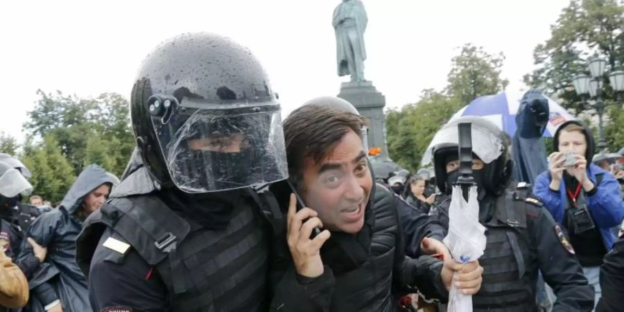 Polizisten führen Demonstranten ab. Foto: Alexander Zemlianichenko/AP