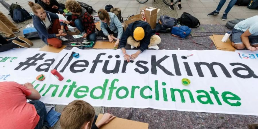 Junge Leute in Hamburg malen Transparente für den Aktionstag
