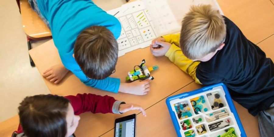 Drei Schüler lernen mit dem Tablet-Computer. Foto: Andreas Arnold/dpa