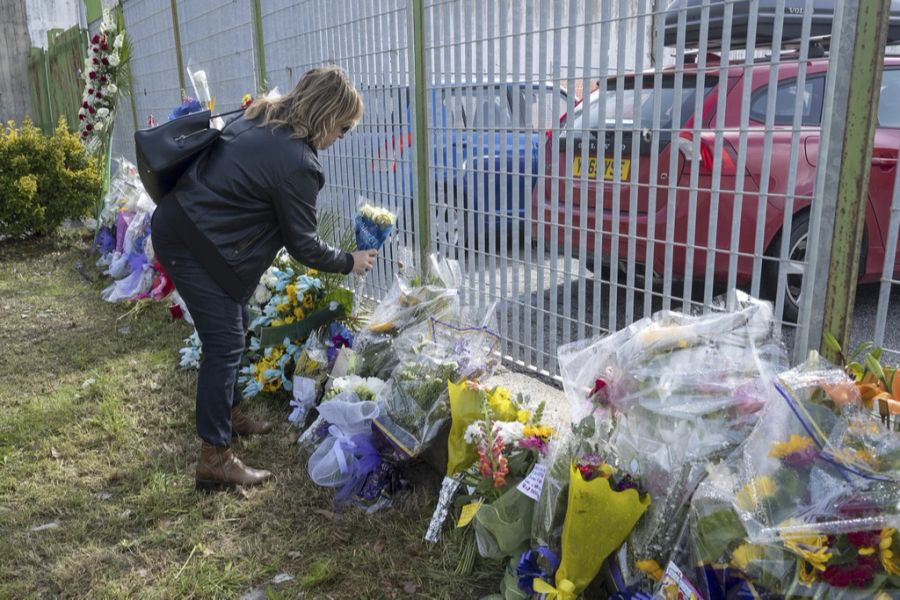 Die Trauer im Dorf ist gross. Eine Frau legt Blumen vor dem Gebäude nieder, in dem die Leichen der Migranten aufbewahrt werden.