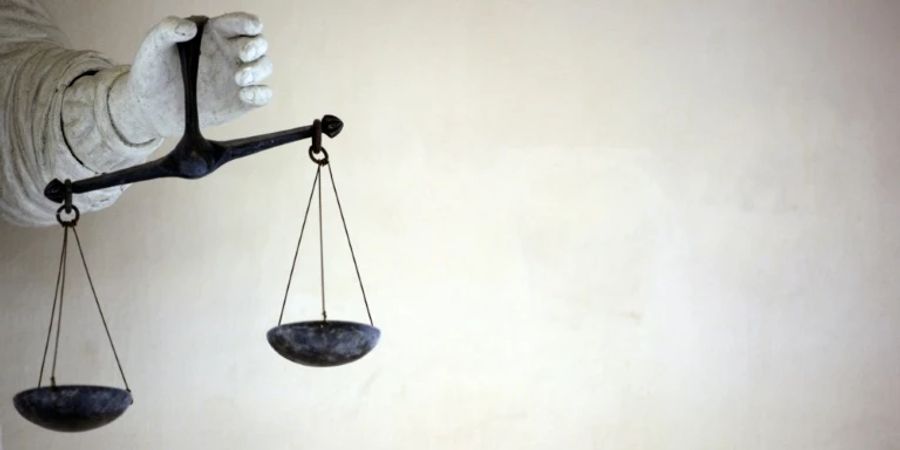 Hand mit Waage als Symbol der Justiz