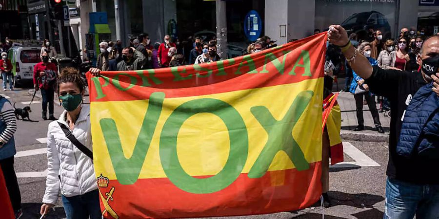 Anhänger der rechtsgerichteten Partei VOX halten eine Spanienfahne mit VOX-Logo auf der Plaza Conde de Casal. Foto: Diego Radames/SOPA Images via ZUMA Wire/dpa