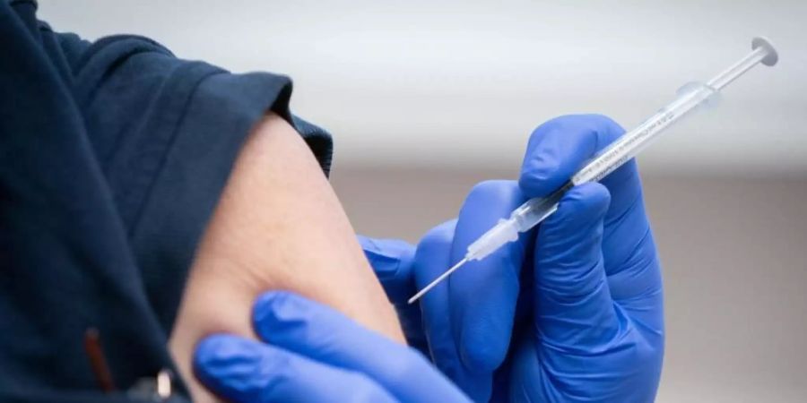 Eine Pflegekraft wird gegen das Coronavirus geimpft. Foto: Kay Nietfeld/dpa
