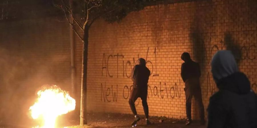 Eine Benzinbombe wurde über die Friedensmauer in West Belfast geworfen. In der britischen Provinz Nordirland kam es erneut zu Krawallen. Foto: Peter Morrison/AP/dpa