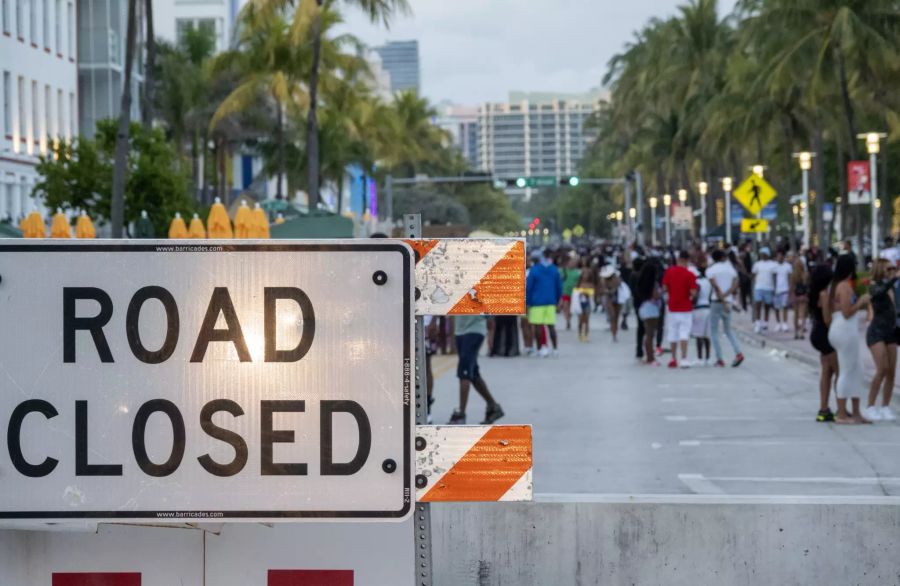 Eine grosse Menschenmenge versammelt sich auf einem Gehweg in Strandnähe, während des Spring Breaks in Miami Beach, Florida, USA, 20. März 2021. Am Samstagabend verhängte die Stadt Miami Beach eine Ausgangssperre für ihr Vergnügungsviertel und schliesst auch die drei Strassen, die an den Strand führen. Die Massnahmen werden in Kraft gesetzt, um grosse Menschenmengen zu kontrollieren, die sich während des Spring Breaks versammelt haben.