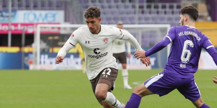 Der Osnabrücker Ludovit Reis (r) kommt gegen Omar Marmoush vom FC St. Pauli zu spät. Foto: Friso Gentsch/dpa