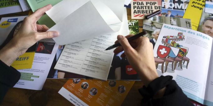 Eine Frau schaut die Wahlzettel für die Nationalratswahlen durch. (Symbolbild) Listen Graubünden