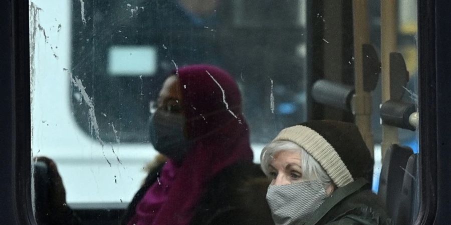 Fahrgäste mit Maske in einem Bus