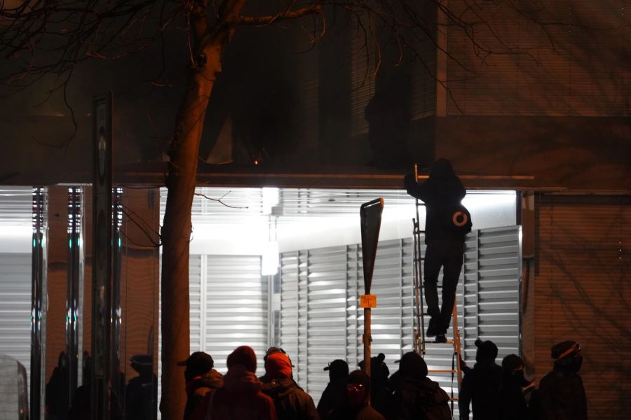 Teilnehmende der Anti-WEF-Demo klettern auf ein Gebäude.