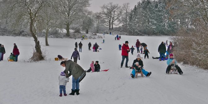 Schlittenfahren rodeln Berg Hang Menschne Kinder Familie Schnee Winter