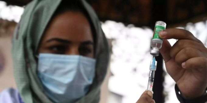 Eine indische Krankenschwester zieht eine Impfspritze auf Eine indische Krankenschwester zieht eine Impfspritze auf