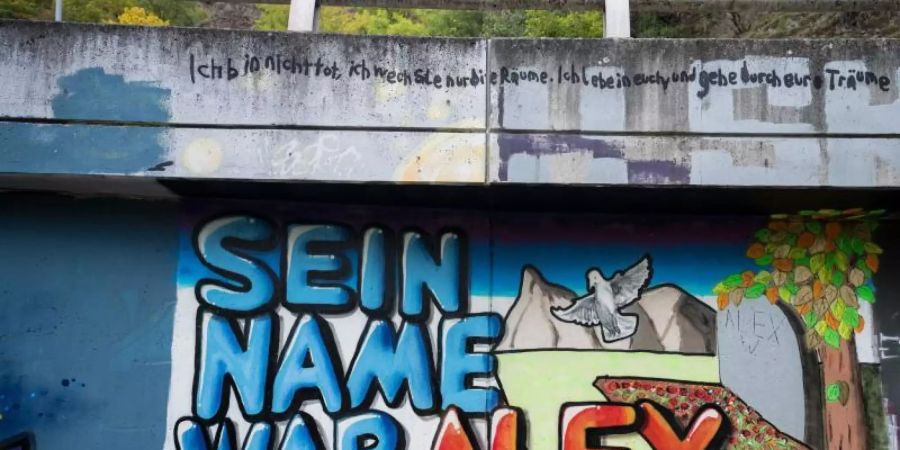 Auf einer Mauer ist ein Graffiti "Sein Name war Alex" für getöteten Tankstellen-Mitarbeiter gesprüht. Foto: Oliver Dietze/dpa