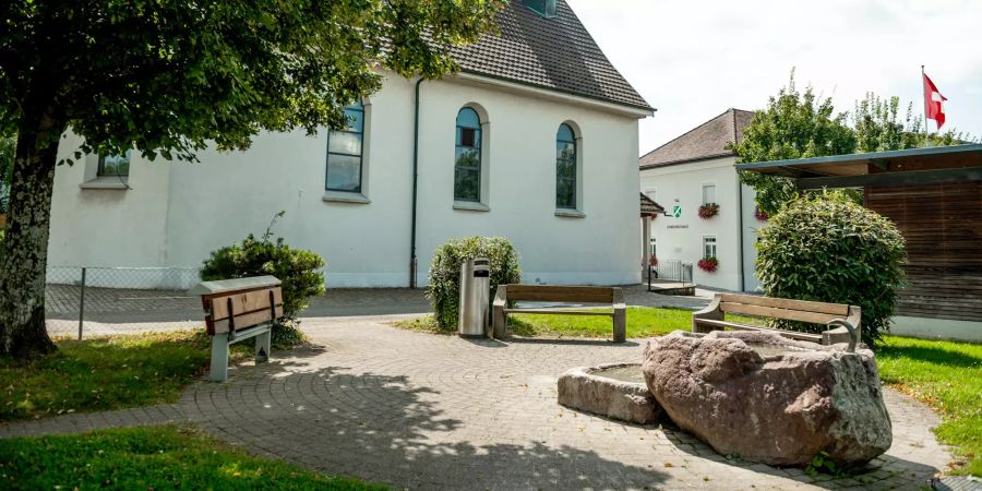 Die Hinterdorfstrasse und im Hintergrund die Fridolinskapelle der Gemeinde Sisseln.