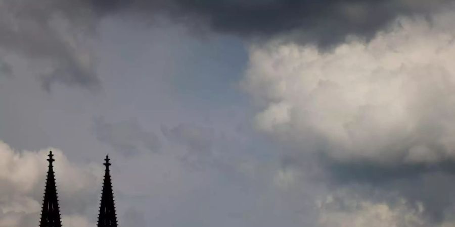 Wolken ziehen am Dom vorbei. (Archivbild). Foto: Oliver Berg/dpa