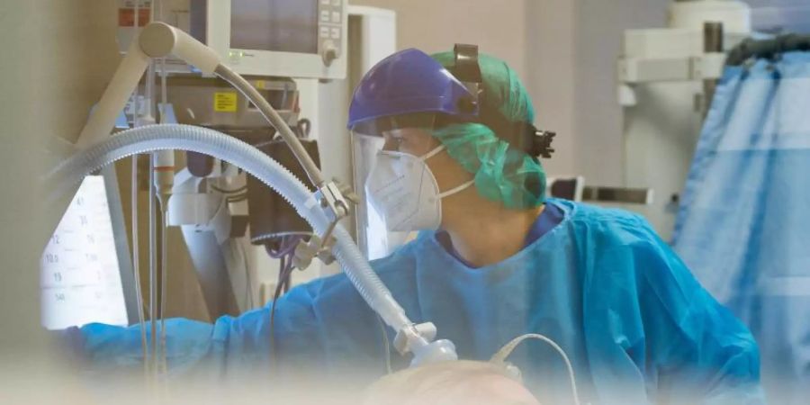 Eine Ärztin kümmert sich auf einer Intensivstation in Trier um einen Corona-Patienten. Foto: Oliver Dietze/dpa