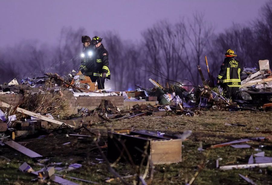 Rettungskräfte durchsuchen die Trümmer der eingestürzten Kerzenfabrik nach Überlebenden des Tornados.