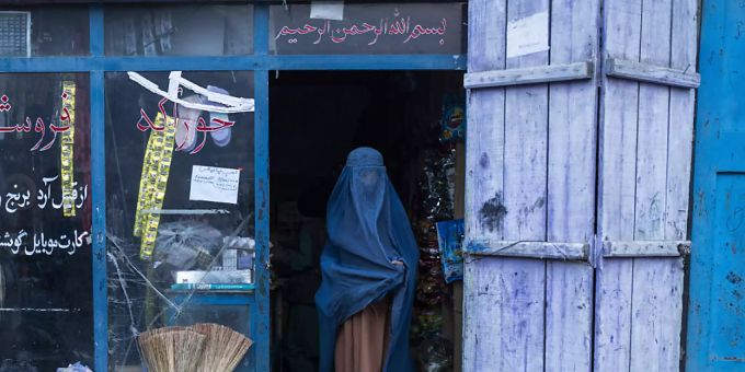 Eine afghanische Frau, die eine Burka trägt, verlässt einen kleinen Laden in Kabul. Bislang haben die Islamisten seit der Machtübernahme Mitte August die Rechte von Frauen wieder deutlich eingeschränkt. Foto: Petros Giannakouris/AP/dpa afghanistan