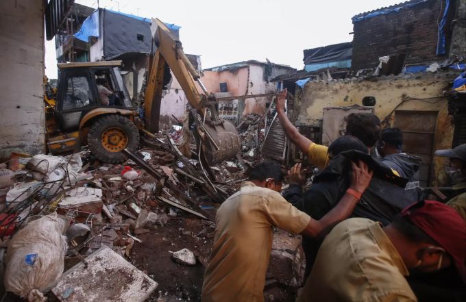Helfer versuchen, Lebende aus den Trümmern zu retten. India Building Collapse