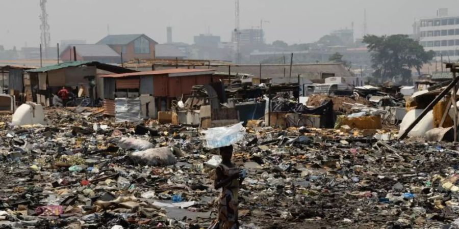 Eine Frau steht auf der Freifläche hinter dem Schrottplatz von Agbogbloshie in Ghana. Foto: Gioia Forster/dpa