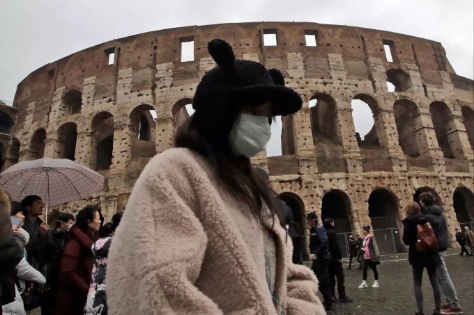 Eine Touristin aus China trägt während eines Besuchs des Kolosseums in Rom einen Mundschutz. Coronavirus - Italien