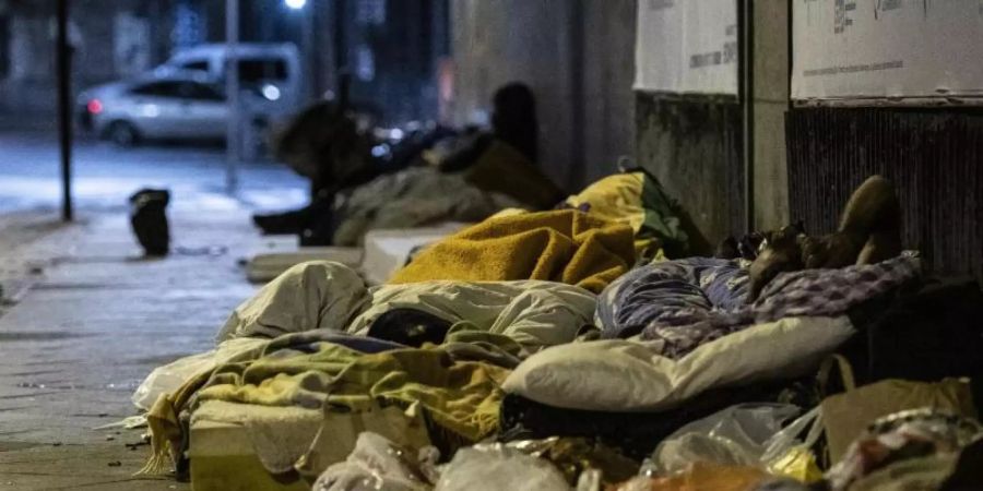 Obdachlose Menschen liegen unter einer Brücke am Bahnhof Zoo. Foto: Paul Zinken/dpa