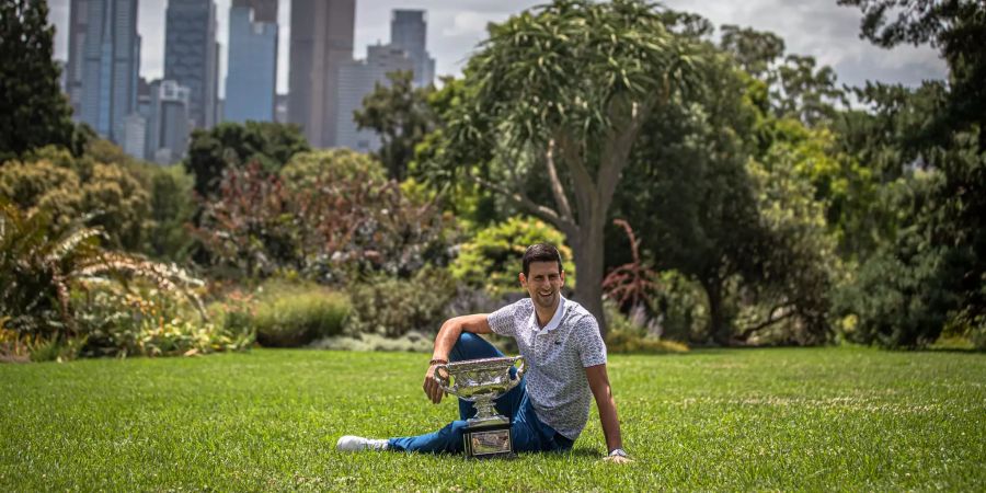 Novak Djokovic posiert vor der Skyline von Melbourne.