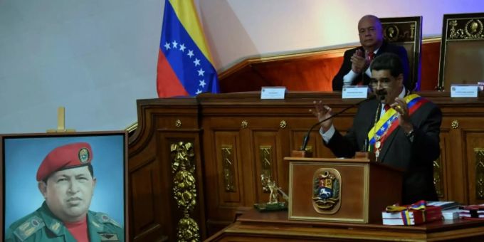 Maduro spricht neben einem Porträt von Hugo Chávez. Hugo Chavez
