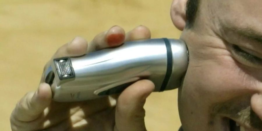 Mann mit elektrischem Rasierapparat