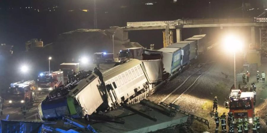 Feuerwehrfahrzeuge stehen um den verunglückten Zug. Foto: Patrick Seeger/dpa