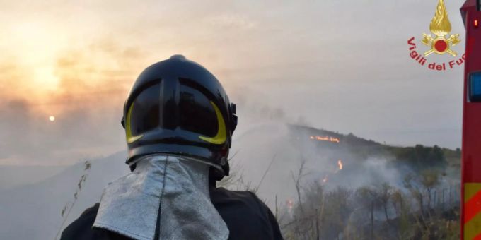 Ein Feuerwehrmann steht vor einem Waldbrand. (Symbolbild) Waldbrand Italien