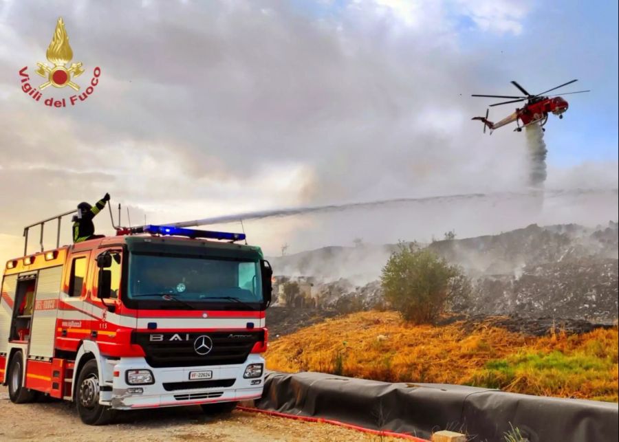 Einsatzkräfte der italienischen Feuerwehr sind in der Luft und am Boden im Einsatz.