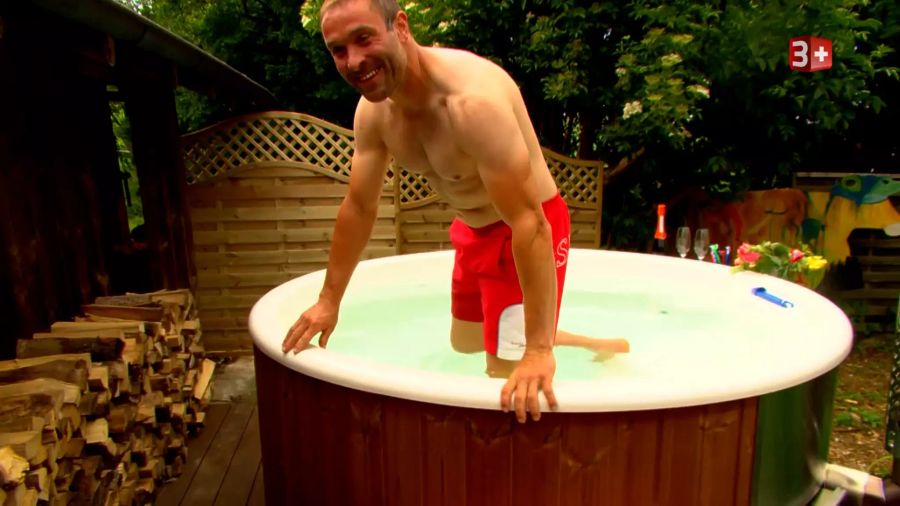 Rolf steigt in knappen Badehosen in den Jacuzzi.