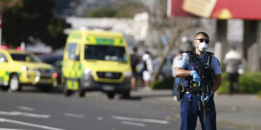 Ein Polizist steht vor dem Supermarkt in Auckland, in dem es zu dem Angriff kam. Foto: Alex Burton/New Zealand Herald/AP/dpa