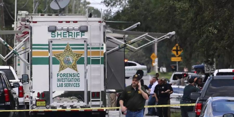 Kriminalbeamte im US-Bundesstaat Florida untersuchen nach einer Schiesserei mit mehreren Toten den Tatort. Foto: Michael Wilson/The Lakeland Ledger via AP/dpa