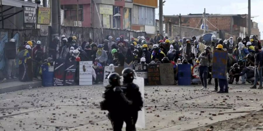 Demonstranten stossen während eines Anti-Regierungs-Protestes in Bogotá mit der Polizei zusammen. Foto: Leonardo Munoz/AP/dpa