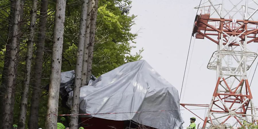 ARCHIV - Ein Absperrband ist um die Trümmer einer Seilbahngondel gespannt, nachdem diese am norditalienischen Monte Mottarone abgestürzt ist. Foto: Luca Bruno/AP/dpa