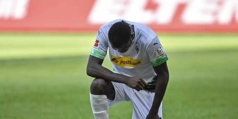 In der Bundesliga kniete der Gladbacher Marcus Thuram zum Zeichen des Protests gegen Rassismus auf dem Spielfeld. Foto: Martin Meissner/AP Pool/dpa