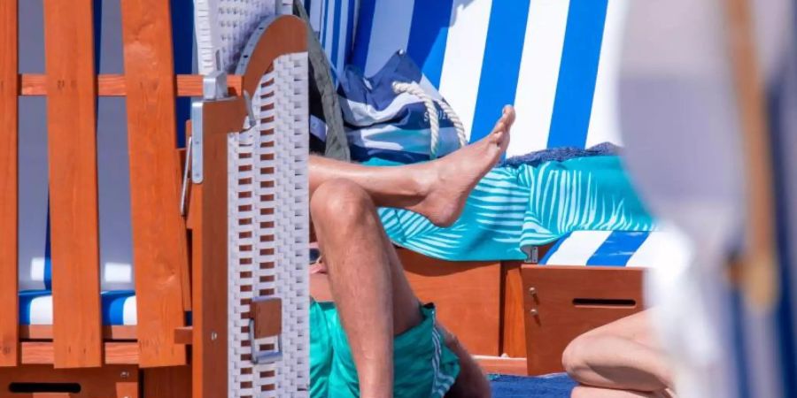 Erste Gäste am Ostseestrand auf der Insel Rügen. Foto: Jens Büttner/dpa-Zentralbild/dpa