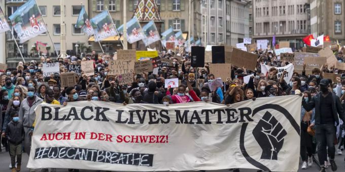 Demonstrierende halten ein Banner mit der Aufschrift «Black Lives Matter - Auch in der Schweiz!» während eines Protests gegen Rassismus und Polizeigewalt. Foto: Georgios Kefalas George Floyd - Basel Coronavirus