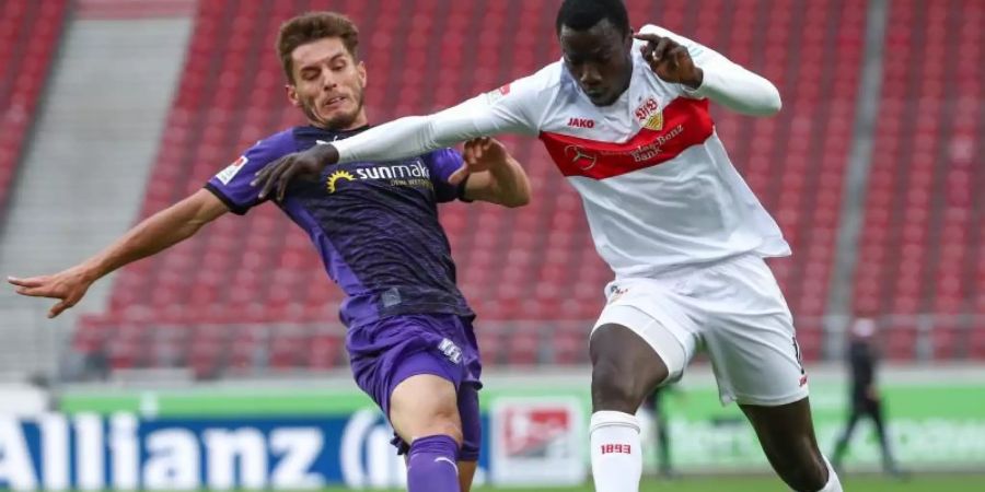 Osnabrücks Bashkim Ajdini in Aktion gegen Tanguy Coulibaly (r) vom VfB Stuttgart. Foto: Tom Weller/dpa-Pool/dpa