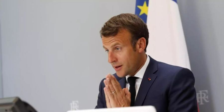 Emmanuel Macron nimmt aus dem Elysee-Palast heraus gestenreich an der WHO-Videokonferenz teil. Foto: Christophe Ena/AP/dpa
