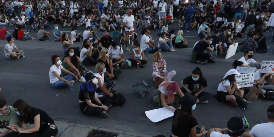 Demonstranten in Belgrad protestieren sitzend gegen die von Präsident Aleksandar Vucic verhängten Corona-Restriktionen. (Foto: Darko Vojinovic/AP/KEYSTONE-SDA)