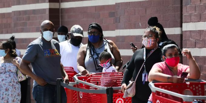 In New York tragen Menschen Schutzmasken, während sie vor einem Kaufhaus warten. Die Stadt ist schwer vom Coronavirus betroffen. Coronavirus - USA