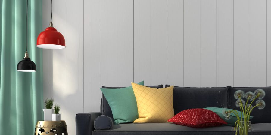 Kräftige Farben lassen ein graues Sofa erstrahlen.
