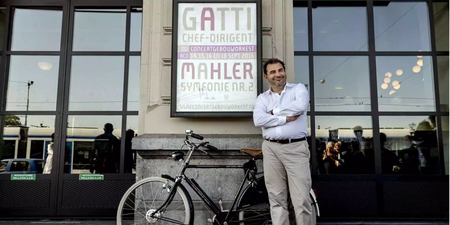 Daniele Gatti, italienischer Dirigent, lächelt neben dem Fahrrad, das ihm zum Start seiner neuen Aufgabe als Chefdirigent des Royal Concertgebouw Orchestra geschenkt wurde.