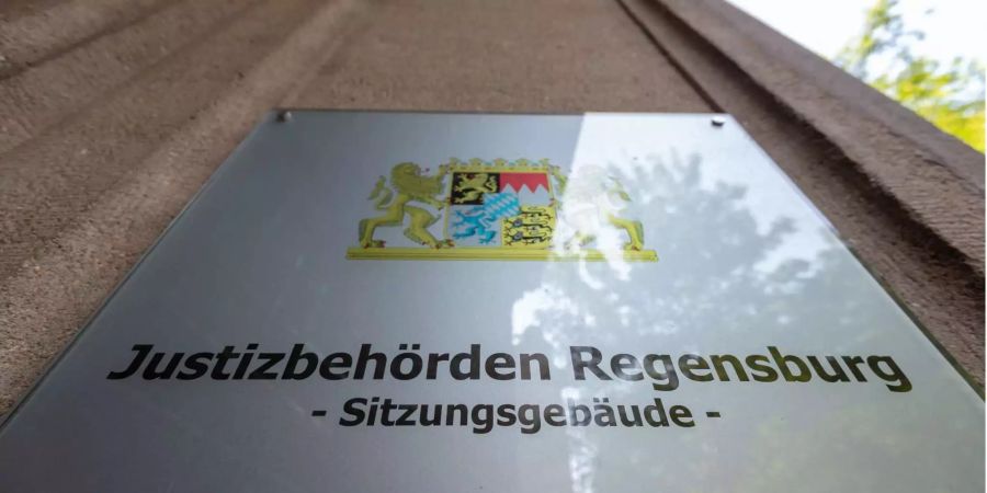 «Justizbehörden – Sitzungsgebäude» steht auf einem Schild am Gebäude des Landgerichts in Regensburg (D).